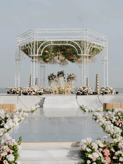 The complete mandap setup with its mirrored aisle, creating a perfect reflection that enhances the structure's beauty and the surrounding floral decor.