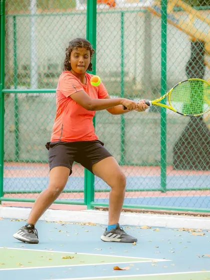 This young player demonstrates great focus as she prepares to strike the orange ball. Our program is designed to build confidence by allowing kids to rally and play points successfully at an early stage.