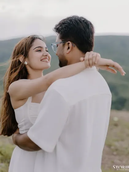 A lovely portrait capturing the couple's gaze as they embrace, with the beautiful green hills behind them.
