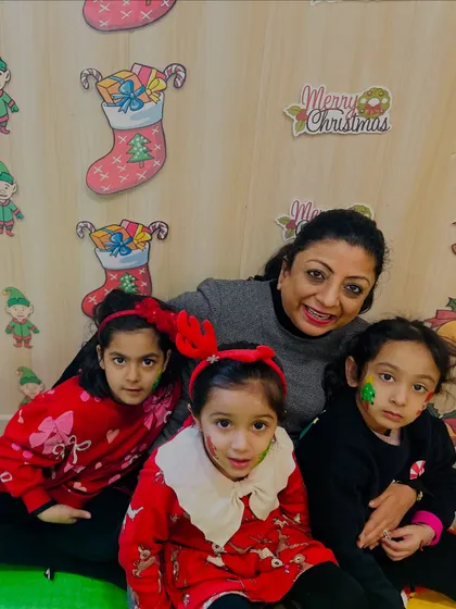 An instructor poses with three happy participants of our Christmas workshop, all with festive face paint.