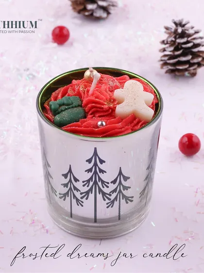 A silver jar with pine tree designs, topped with a gingerbread man.