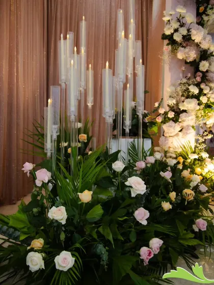Detail is key. For this reception, I created modern candle displays with tall glass holders set amidst lush greenery and soft pink roses, adding a warm and romantic glow to the space.