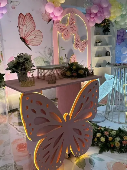 The butterfly-shaped table and neon-lit number "5" centerpiece from another angle.