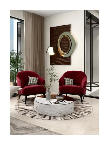 This image illustrates our suggestion for using bold color. In a neutral setting, a pair of our custom red velvet armchairs creates a strong visual anchor and a warm, inviting conversation area around a cylindrical marble coffee table.