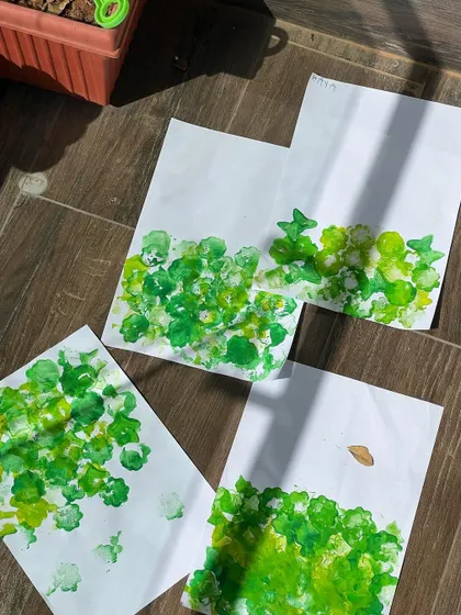 The first layer of our sponge-painted gardens. The children use different shades of green to create depth and texture.