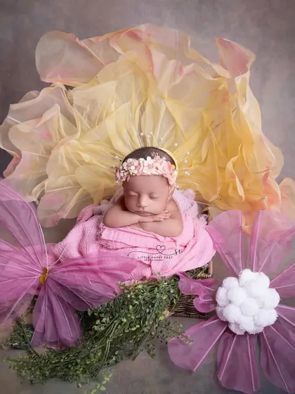 A fantasy flower setup. The oversized, whimsical flowers made of fabric and tulle create a magical, larger-than-life garden for this tiny sleeping beauty.