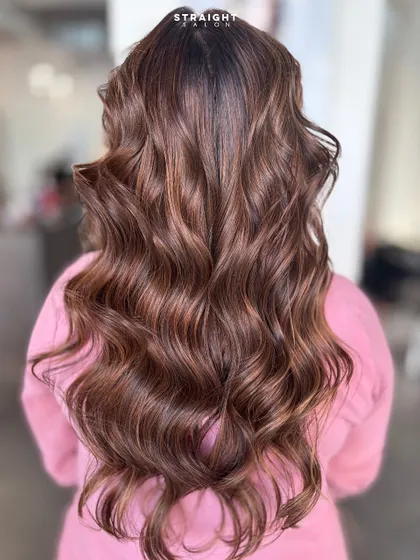 A perfect example of my signature balayage work. I hand-painted these highlights to create a seamless blend of rich brunette and caramel tones, finished with soft, voluminous waves.