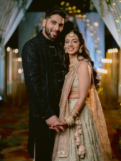 A classic portrait of the couple, Zaee and Kartik, holding hands and smiling for the camera at their Sangeet.