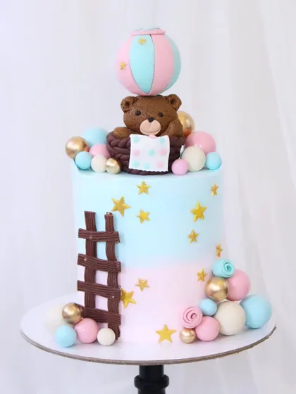 A sweet "Pink or Blue, We Love You" cake for a baby shower. The design features a pink and blue ombre effect, with a cute teddy bear in a hot air balloon, ready for a new adventure.