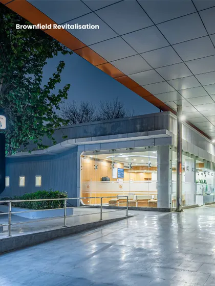 This night view of the Northern Railway Diagnostic Centre entry canopy emphasizes how brownfield revitalization can create modern landmarks. The design provides shelter and a clear point of entry, integrating functional needs with a contemporary aesthetic.