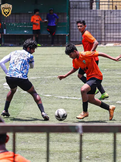 An action shot from the MFA First Division League, showing a player dribbling past the opposition.