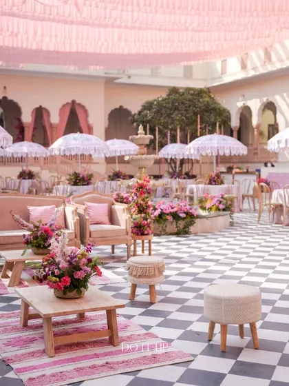 An overview of the courtyard setup, with pink-themed tables, custom-printed umbrellas, and comfortable lounge areas. The design transformed the space into a chic, Parisian-style cafe.