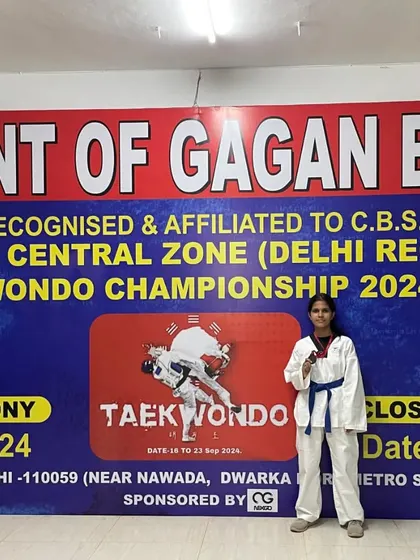 Anushka Sharma posing with her bronze medal in front of the official championship banner. A proud moment for her and the academy.