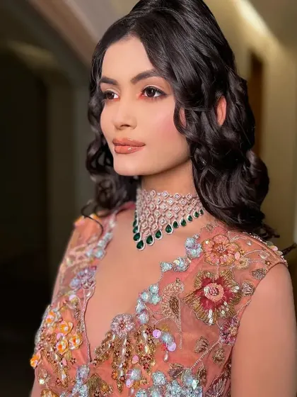 A close-up on the bride's soft makeup and the diamond and emerald choker.