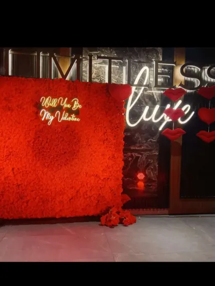A bold and dramatic Valentine's backdrop. This features a wall covered in red flowers with a "Will You Be My Valentine" neon sign, creating a very passionate and immersive photo spot.