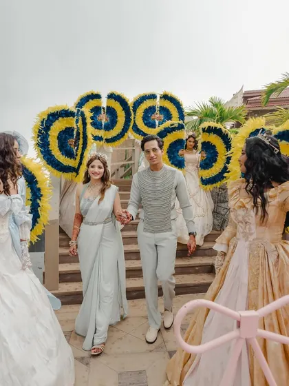 A grand entrance, with performers in elaborate costumes creating a path for the couple.