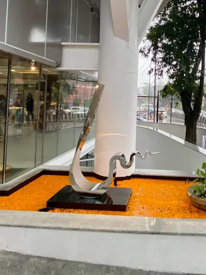 A view of the sculpture by Tarik Currimbhoy, showing its elegant form against the structural elements of the museum. This placement was carefully considered to create a landmark at the building's public entrance.