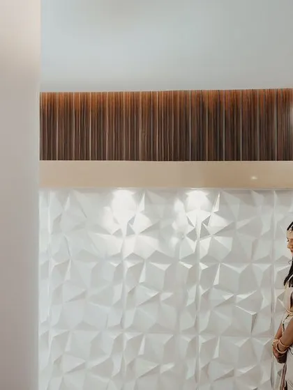 A minimalist composition focusing on the couple against a textured white wall. This modern approach to a wedding portrait highlights their connection without any distractions.