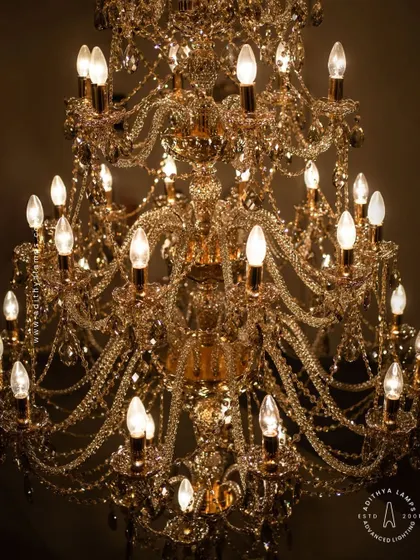 A detailed look at our magnificent multi-tiered crystal chandelier. Each arm is draped with shimmering crystal beads that reflect and refract light, creating an unparalleled sparkle. This fixture is a testament to classic European design and meticulous craftsmanship.
