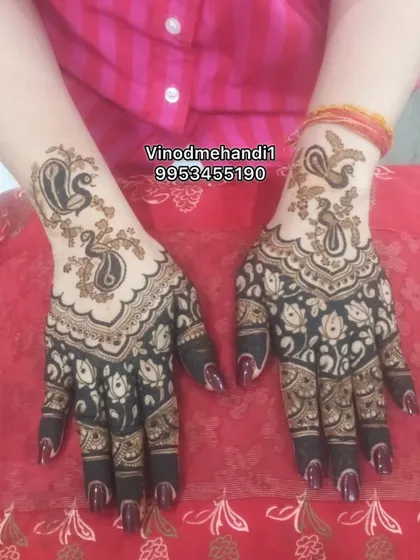 This design uses negative space to highlight the twin peacock motifs on the back of the hand. The dark, filled-in patterns on the palm and fingers create a beautiful contrast.