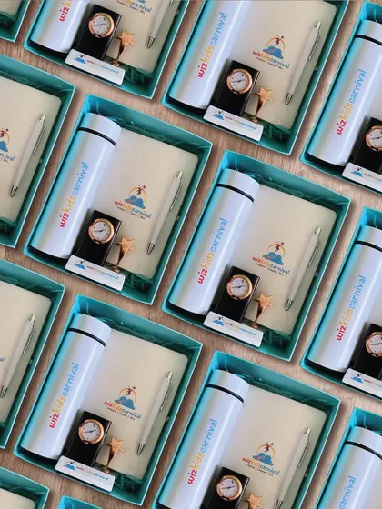 Branded gift boxes designed for employee appreciation at Wizkids Carnival. This set includes a custom-branded flask, notebook, pen, and a desk clock, all presented in a vibrant, stylish box.