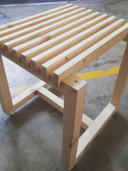 The finished slatted stool, a simple yet elegant piece that requires precise cutting and joinery to achieve its clean, geometric form.