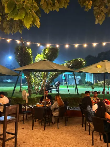 An evening view from the patio, where you can see golfers still practicing on the floodlit range.