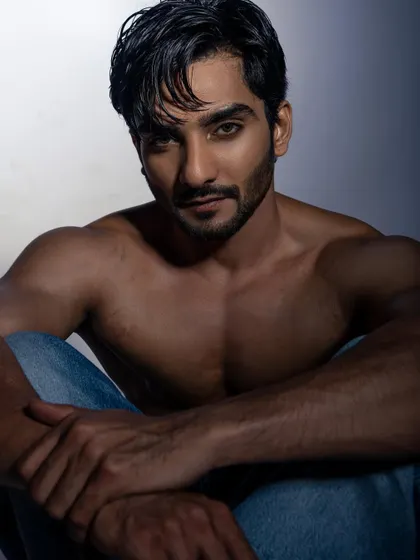A moody, shirtless portrait that showcases the model's physique and intense gaze. A must-have for a male model's book.
