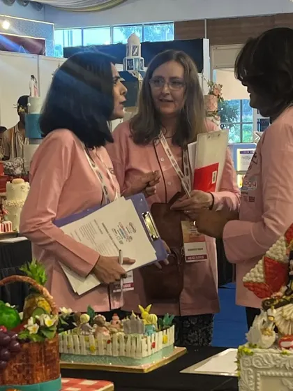 The judges carefully inspecting my award-winning one-tier cake at the competition. Every tiny detail was crafted with passion and precision.