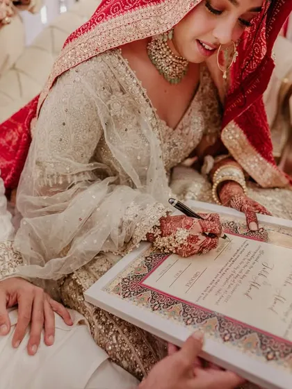 The bride signs her Nikah contract, a moment of commitment and grace.