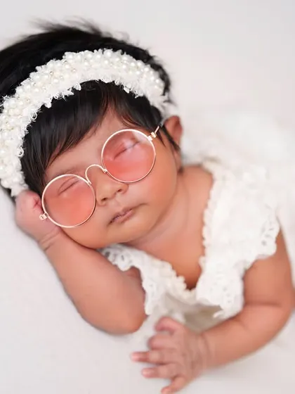 Adding a touch of cool with pink sunglasses to this otherwise simple and classic white lace outfit.