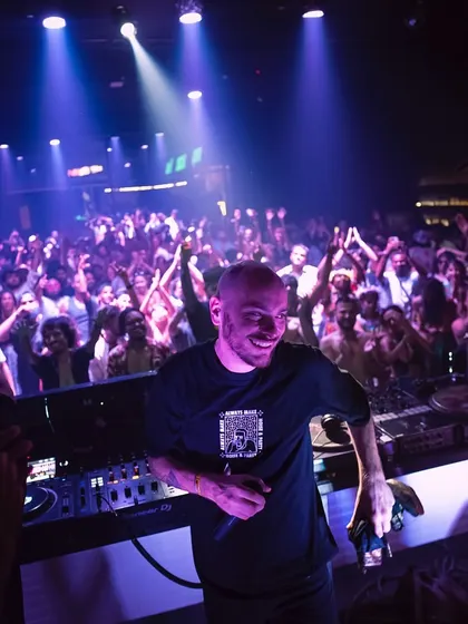 A DJ smiles as he looks out at the massive crowd at Goa Sunsplash. It's a rewarding moment to see the dancefloor completely packed and loving the selections.