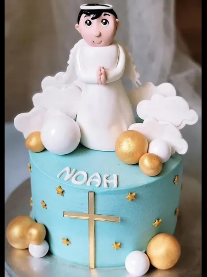 Baptism cakes are one of my favorites to make. This one for Noah features a sweet angel boy topper, clouds, and gold cross details on a serene blue cake.