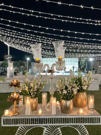 An elegant decor cart with a crystal candelabra, candles, and white flowers, perfect for a sophisticated, vintage-themed event.