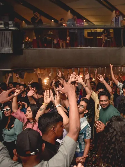A wide shot of the dance floor with hands in the air. A classic sign of a great party.
