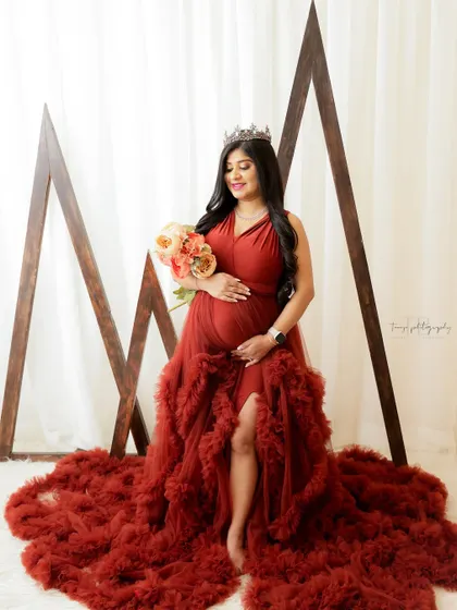 A stunning portrait in a rich, rust-colored gown. The modern geometric props in the background add a unique and artistic touch.