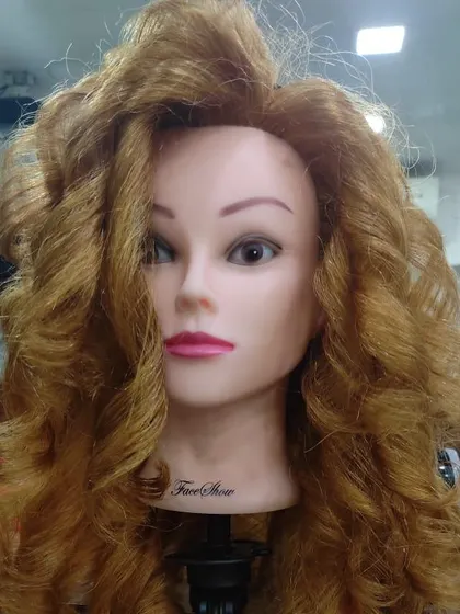Even on a mannequin, the skill is clear. A student's practice with creating full, bouncy curls, showing their control over heat styling tools and techniques.