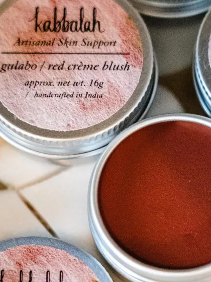 The 'Gulabo' red crème blush, with its label clearly visible. This artisanal product is a wonderful, natural alternative to conventional makeup.