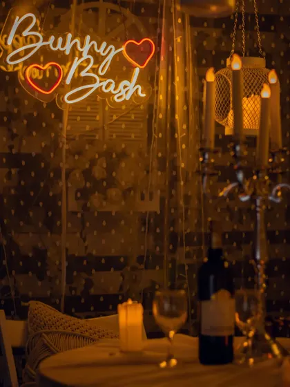 My signature "Bunny Bash" neon sign adds a personal and playful touch to this intimate anniversary dinner. The warm lighting and candlelit details create a cozy and celebratory atmosphere.