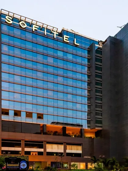 A ground-level perspective of the Sofitel, showcasing the grand entrance and podium levels that welcome guests into a world of sophisticated design and warm hospitality.