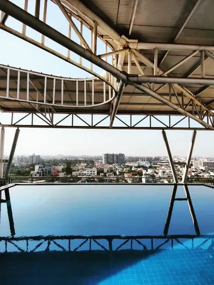 A view of the rooftop infinity pool at Palm Bellagio, overlooking the city of Raipur.