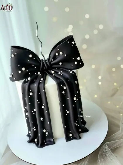 A stunning black and white bow cake. The contrast is incredibly chic, and the delicate pearl details on the black bow add a touch of glamour.