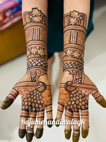 Symmetrical peacock designs are a timeless choice for brides. Here, the peacocks on the palms are surrounded by dense, traditional filler patterns, with lotus motifs on the wrist for a graceful finish.