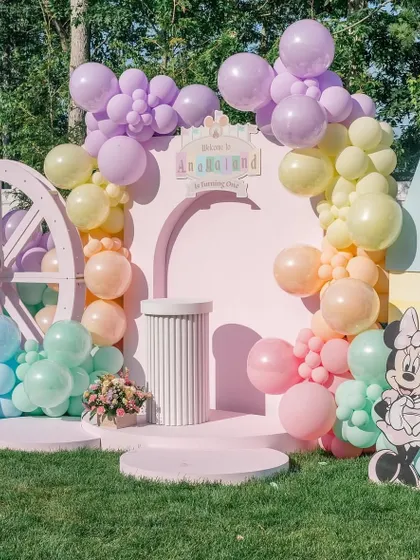 A close-up of the main stage, highlighting the pastel balloon colors and the cute Minnie Mouse cutout.