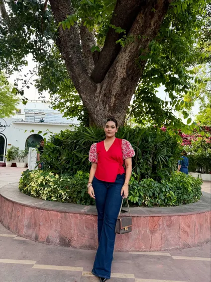 A full-length shot of the red top and flared jeans, a classic combination with a modern twist.