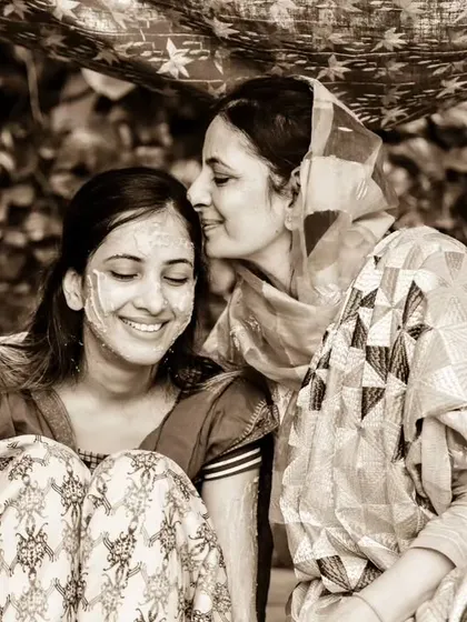 A sepia-toned photo of a mother's gentle affection for her daughter during the Haldi. This timeless image focuses on emotion and connection.