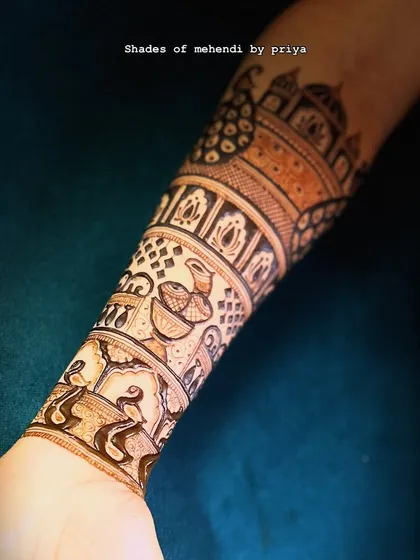 A close-up of the intricate bands on the forearm, featuring diyas, peacocks, and geometric patterns.