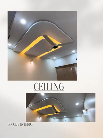 A modern false ceiling design with a recessed rectangular section and curved edges, highlighted by warm yellow backlighting.