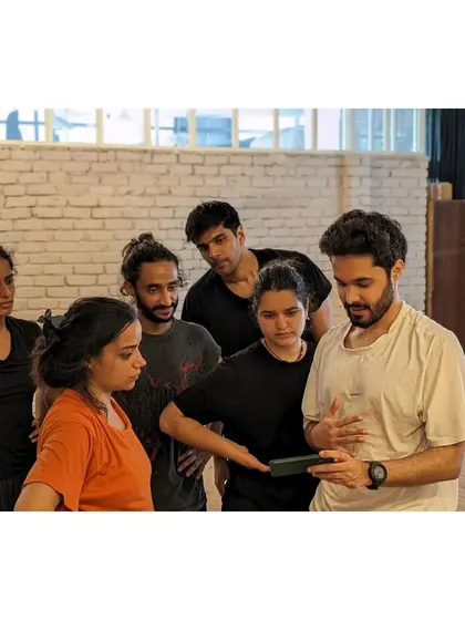 The team gathers around a phone to review a recorded sequence. We believe in learning from each other and providing constructive feedback.