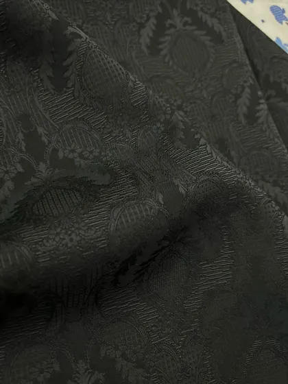 A black-on-black jacquard fabric, featuring a subtle pattern for an elegant and understated evening jacket.